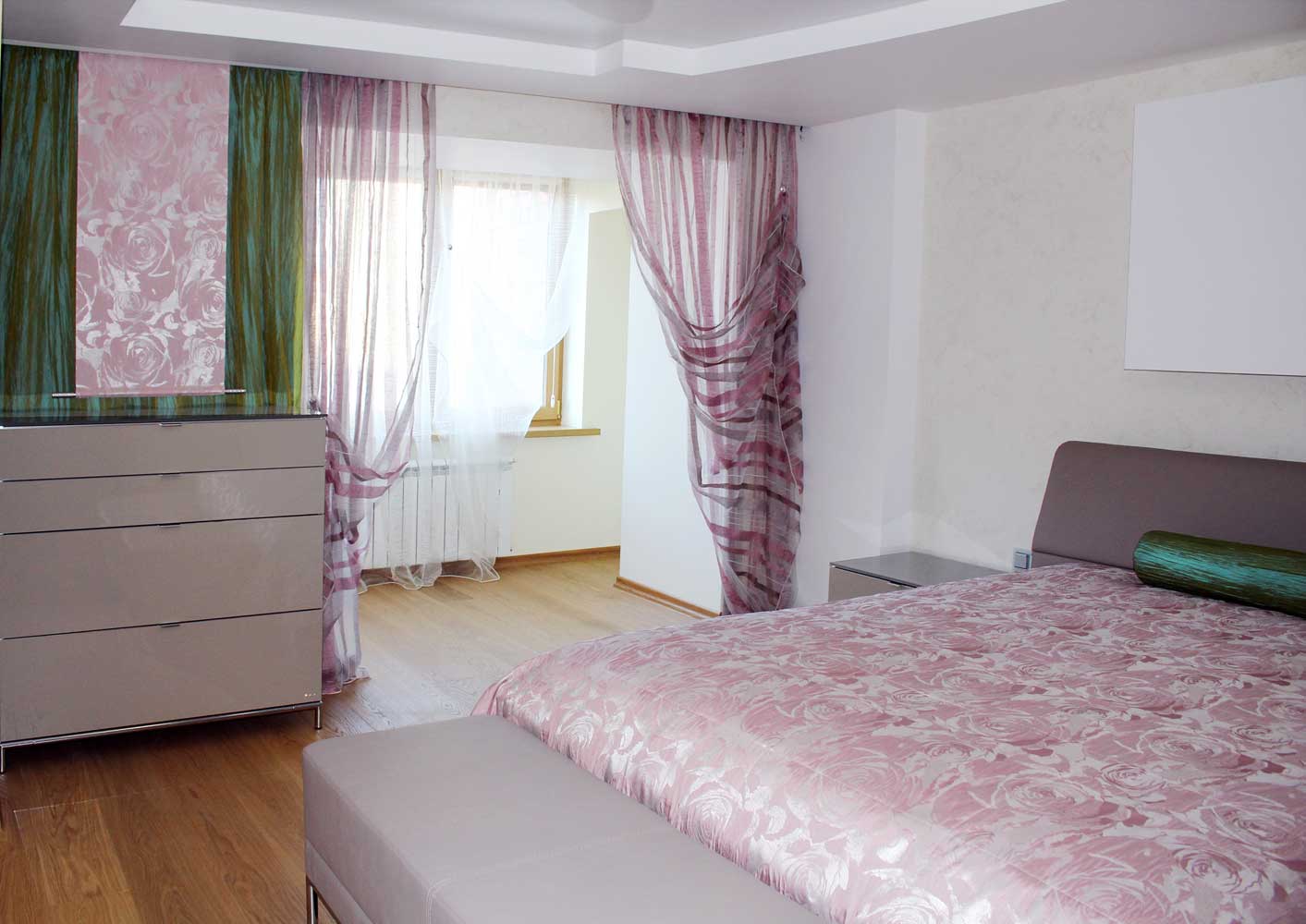 Прозрачные легкие занавески и декоративная панель с розами вбольшой спальне